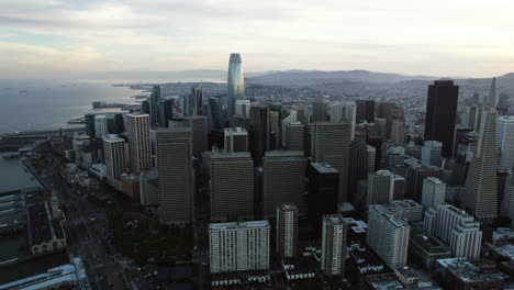 Drone-shot-rising-in-front-of-the-skyline-of-San-Francisco,-in-gloomy-CA,-USA