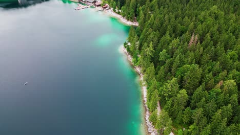 Lake-Eibsee-in-Bavarian-Alps,-drone-flying-over-pine-trees-in-Germany