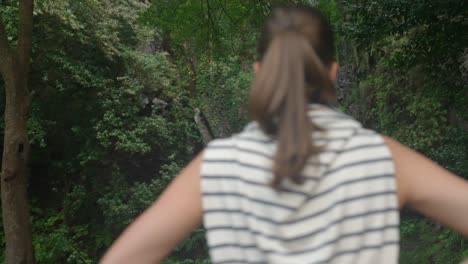 model-girl-looking-at-a-waterfall-in-the-jungle-in-Madeira-Portugall-,-deep-in-the-green-forest