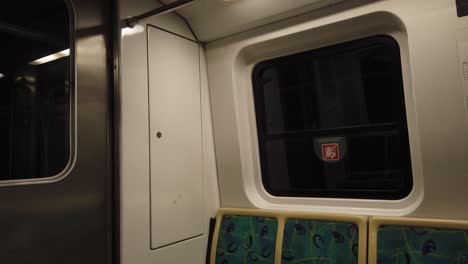 Empty-Seats-Doors-and-Metallic-Window-of-Subway-Underground-Metro-Railway-Dark-Tunnel
