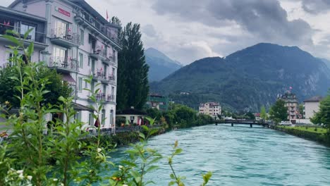 Interlaken-Switzerland-Immersive-Travel-Tourism-Mountainside-Valley-Resort-City,-Europe,-Walking,-Rainy-Day,-4K-|-Looking-Around,-Shaky,-Water,-River,-Lake,-Restaurant,-Hotel,-Flowers,-Trees,-Distance