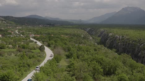 Beautiful-footage-from-a-drone,-Land-Rovers-driving-on-the-road-in-beautiful-nature