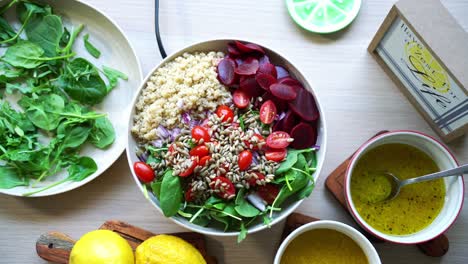 Overhead-aerial-view-of-quinoa-salad-beets-seeds-spinach-and-tomatoes-with-salad-dressing-on-the-side