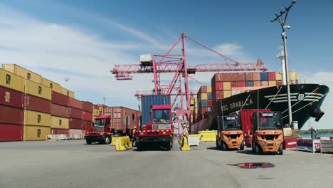 Tracks-carrying-heavy-shipping-containers-from-Port-of-Montreal-cargo-vessel-in-dockyard