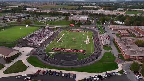 Wide-aerial-shot-of-high-school-football-game-in-USA-under-Friday-night-lights
