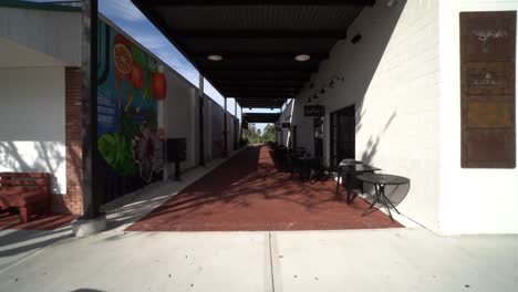 Wide-angle-push-in-below-covered-roof-and-side-street-alley-of-shops-at-Downtown-Clermont-Florida