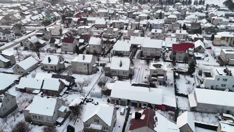 Snow-covered-white-suburban-neighborhood-with-grey-buildings-and-empty-roads