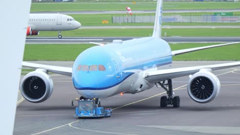 Schlepper-Und-Verkehrsflugzeug-Hielten-Auf-Der-Landebahn-Des-Flughafens-Schiphol,-Amsterdam