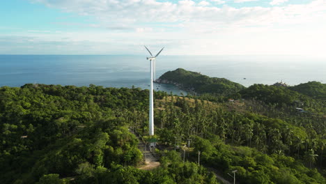 Luftaufnahme-Einer-Isolierten-Windkraftanlage-Zur-Erneuerbaren,-Sauberen,-Grünen-Energieversorgung-Auf-Einem-Grünen-Hügel,-Umgeben-Von-Unverschmutzter-Vegetation,-Reiner-Natur-Und-Mit-Meer