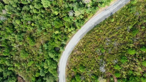 Winding-narrow-asphalt-road-through-mountain-range,-drone-top-view