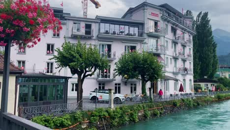 Interlaken-Switzerland-Immersive-Travel-Tourism-Mountainside-Valley-Resort-City,-Europe,-Walking,-Rainy-Day,-4K-|-Looking-Around,-Shaky,-Water,-River,-Lake,-Restaurant,-Hotel,-Flower,-Bridge,-Traffic