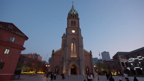 Myeongdong-Cathedral-at-Sunset,-People-Travel-Around-Taking-Photos
