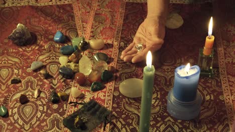 Close-up-shot-of-a-mystical-healer-performing-a-ritual-with-magic-gems-and-swinging-the-pendulum-to-read-the-future-and-the-energy-of-the-magic-rocks