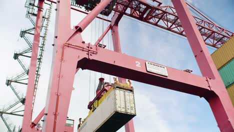 Port-of-Montreal-heavy-crane-carefully-loading-shipping-container-onto-haulage-lorry-in-dockyard