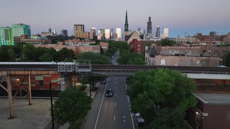 Verkehr-Unter-Hochbahngleisen-In-Chicago-Mit-Blick-Auf-Die-Skyline-Bei-Sonnenuntergang