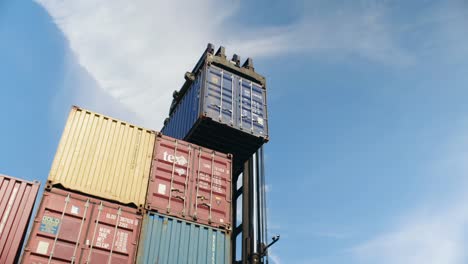 Forklift-carefully-stacking-heavy-shipping-container-in-Port-of-Montreal-storage-dockyard
