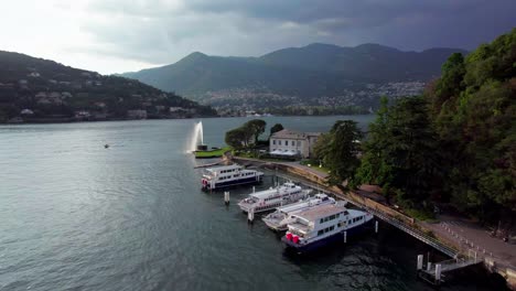 Aerial-over-boats-docked-in-Lake-Como-near-Como-fountain,-Italy