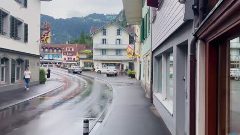 Interlaken-Switzerland-Immersive-Travel-Tourism-Mountainside-Valley-Resort-City,-Europe,-Walking,-Rainy-Day,-4K-|-Looking-Around,-Shaky,-Water,-River,-Lake,-Restaurant,-Women,-Man,-Running,-Car,-Road
