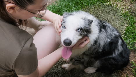 Young-woman-spends-time-with-her-Australian-Shepherd-in-her-backyard
