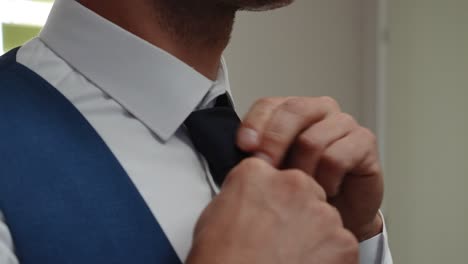 groom's-preparing-his-tie-close-up