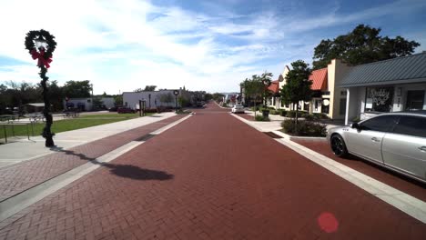 Wide-angle-dolly-with-small-sun-flare-as-shadows-of-streetlamps-and-wreaths-in-Clermont-Florida