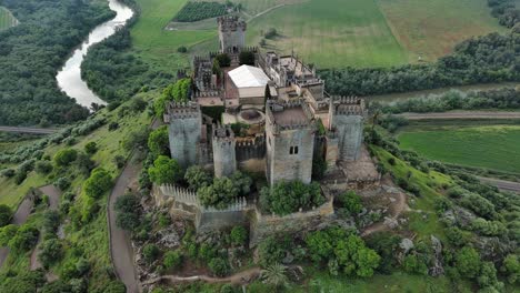 Majestätische-Luftaufnahme-Der-Burg-Almodovar-Mit-Dem-Fluss-Guadalquivir-Dahinter