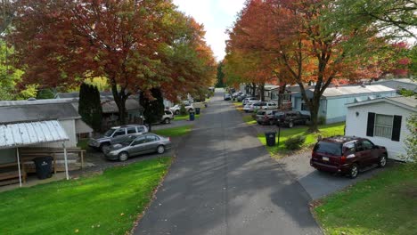 Mobile-homes-and-colorful-trees-lining-trailer-park-street-during-autumn