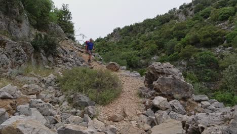 A-solo-male-white-hiker-walks-downhill-on-an-easy-path-on-the-Lycian-Way-in-Turkey