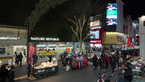 People-visit-Myeongdong-shopping-district-night-market,-street-food-stalls-in-Seoul