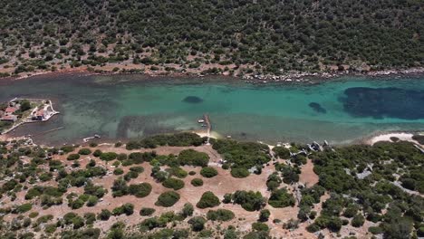 High-angle-aerial-overview-of-ancient-underwater-ruins-in-turquoise-green-blue-water-in-deep-channel,-Aperlai-Turkey