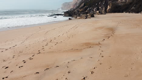 Eine-Fesselnde-Luftperspektive-Der-Bezaubernden-Sandstrände-Von-Nazaré,-Portugal,-Wo-Goldener-Sand-Eine-Mit-Faszinierenden-Spurenmustern-Geschmückte-Leinwand-Bildet