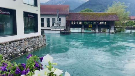 Interlaken-Switzerland-Immersive-Travel-Tourism-Mountainside-Valley-Resort-City,-Europe,-Walking,-Rainy-Day,-4K-|-Looking-Around,-Shaky,-Water,-River,-Lake,-Restaurant,-Wind,-Flower,-Bridge,-Trees