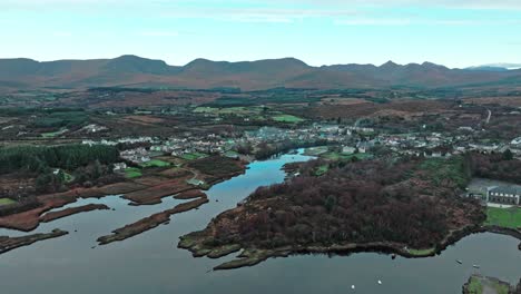 Drone-flying-to-Sneem-Village-on-The-Ring-Of-Kerry-Ireland-early-morning-in-autumn-with-mountains-in-background-wild-Atlantic-way