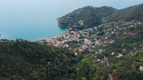 Sunny-coastal-town-in-valley,-drone-aerial-panorama