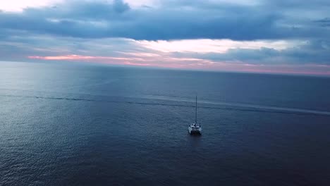 Orbital-drone-shot-of-sailboat-near-the-coast-of-Los-Cabos-in-Mexico