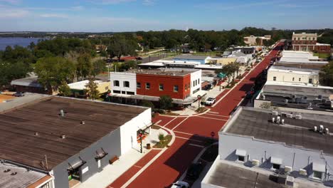 Drone-orbit-around-red-and-white-brick-building-at-corner-intersection-of-Clermont-Florida