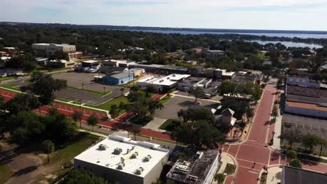 Drone-orbits-around-empty-parking-lot-off-historic-main-street-of-Clermont-Florida-at-midday