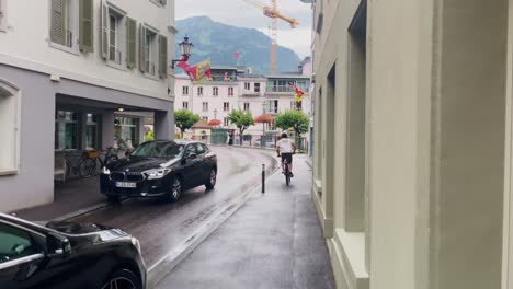Interlaken-Switzerland-Immersive-Travel-Tourism-Mountainside-Valley-Resort-City,-Europe,-Walking,-Rainy-Day,-4K-|-Looking-Around,-Shaky,-Water,-River,-Lake,-Restaurant,-Traffic-Jam,-Biker-Speeding