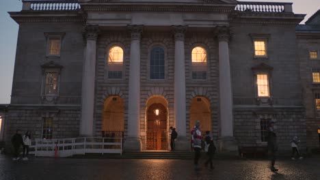 The-illuminated-columned-front-of-Trinity-College-in-Dublin,-Ireland