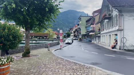 Interlaken-Switzerland-Immersive-Travel-Tourism-Mountainside-Valley-Resort-City,-Europe,-Walking,-4K-|-Looking-Around,-Shaky,-Water,-River,-Lake,-Restaurant,-Parked-Cars,-Family,-Neighborhood,-Biker