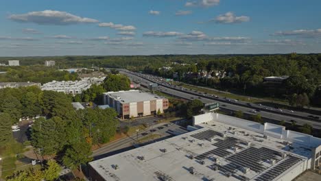 Aerial-flyover-factory-buildings-and-highway-in-woodland-landscape-area-of-America-at-sunset