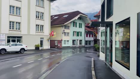 Interlaken-Switzerland-Immersive-Travel-Tourism-Mountainside-Valley-Resort-City,-Europe,-Walking,-Rainy-Day,-4K-|-Looking-Around,-Shaky,-Water,-River,-Lake,-Restaurant,-Bikers-Speeding,-Group,-Traffic