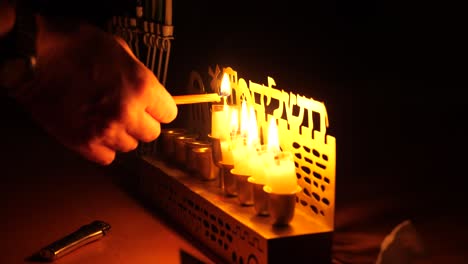 Person-lighting-the-Shamash-candle-of-the-forth-day-of-Hanukkah-festival