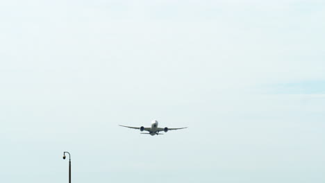 Un-Avión-Capturado-Desde-Su-Parte-Inferior-Mientras-Despega,-Revelando-Un-Cielo-Azul-Y-Nubes,-Aeropuerto-En-Tailandia.