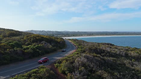 Cinematic-drone-shot-of-scenic-road-along-coast-line-of-Western-Australia-at-sunset-with-cars-driving
