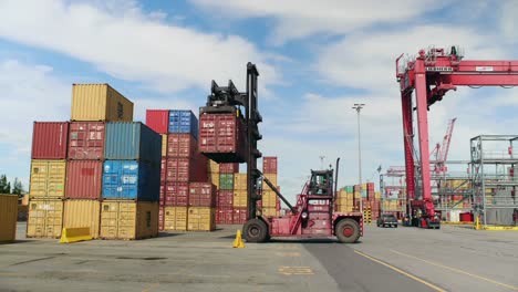 Forklift-truck-stacking-heavy-shipping-container-in-Port-of-Montreal-dockyard