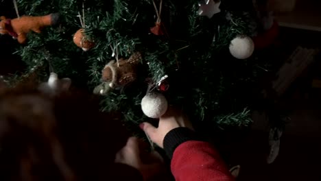 Woman-decorating-a-Christmas-tree-with-felt-tree-decoration-4K
