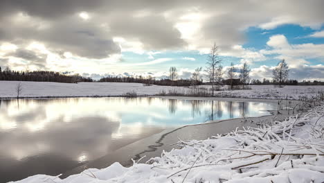 Time-lapse-De-Nubes-Moviéndose-Sobre-Un-Lago-Reflectante-Rodeado-De-Nieve