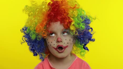 Little-Child-girl-clown-in-wig-making-silly-faces.-Fool-around,-singing,-showing-tongue.-Halloween