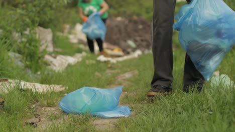 Freiwilligenteam-Räumt-Schmutzigen-Park-Von-Plastiktüten-Und-Flaschen-Auf.-Reduzieren-Sie-Die-Verschmutzung-Durch-Zellophan